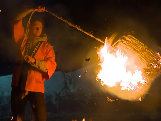 Men is swinging fire around his body during traveling japan and visiting a local winter festival.