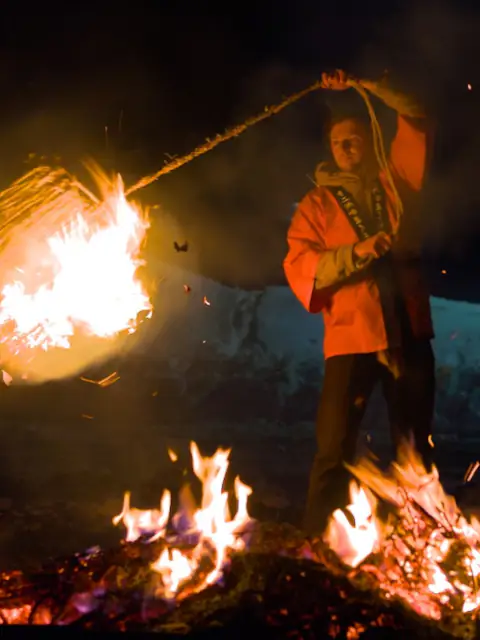 Men is swinging fire around his body during traveling japan off the beaten path and visiting a local winter festival.